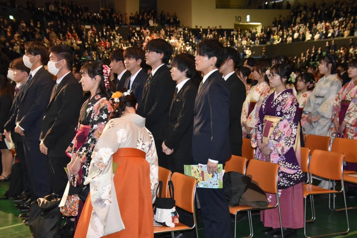 国歌斉唱する卒業生